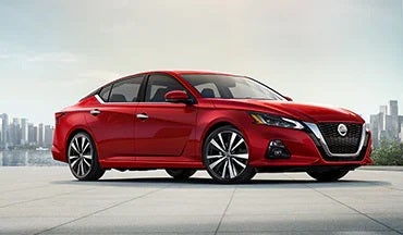 2023 Nissan Altima in red with city in background illustrating last year's 2022 model in Granite Nissan in Rapid City SD
